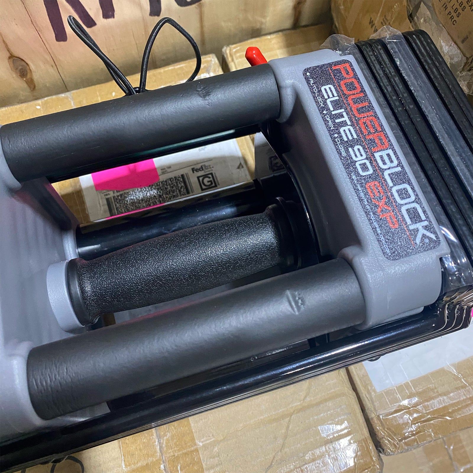 An open box PowerBlock Elite EXP 90 showing some slight damage to the handle